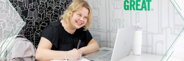 student smiling on laptop