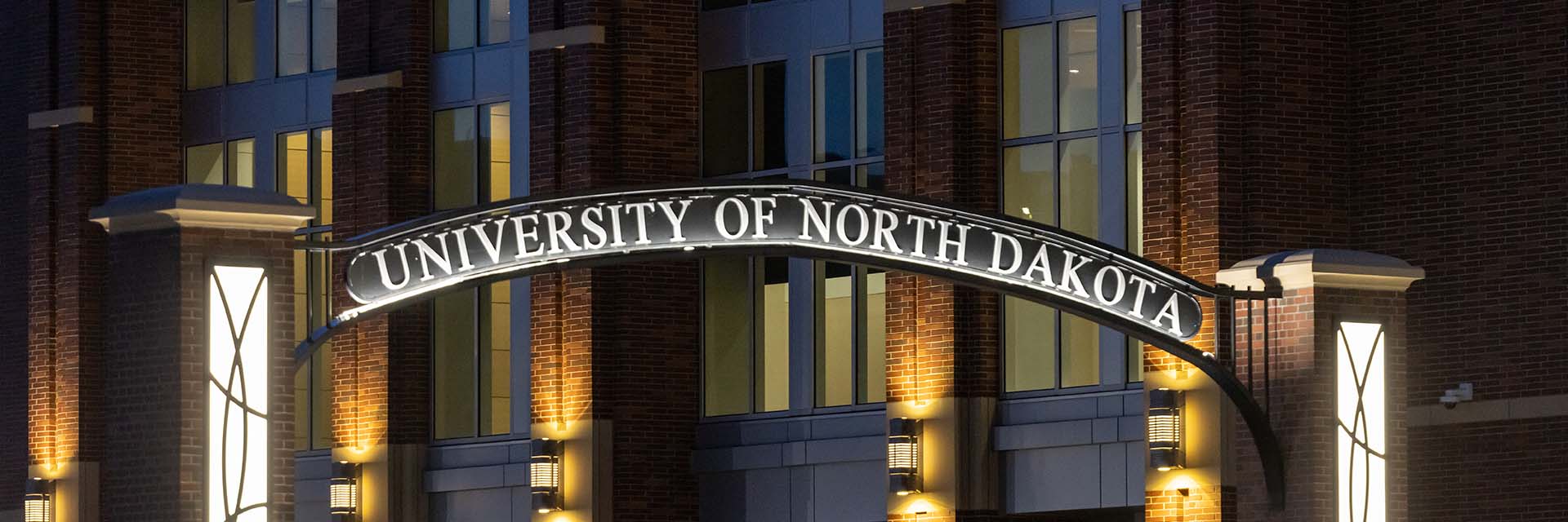und campus sign lit up at night