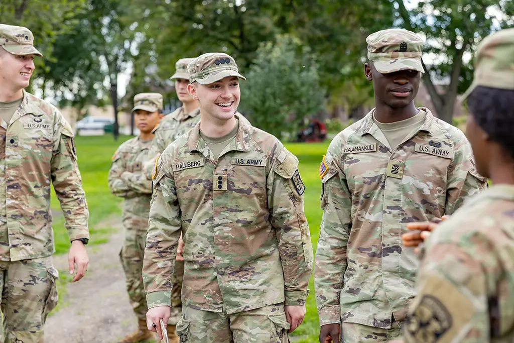 U.S. Army ROTC soldiers in camouflage uniforms talking outdoors
