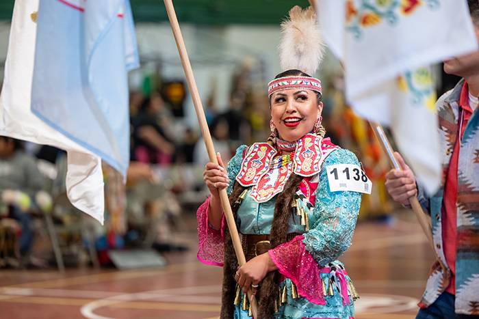 dancer with flag at Wacipi Powwow