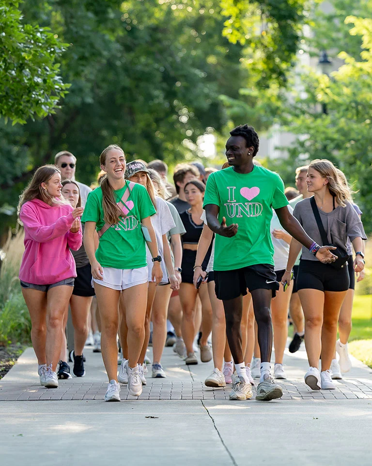 group of students walking on campus sidewalk