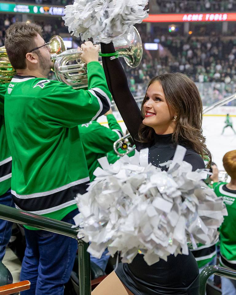 A hockey player skates out of the bench with green smoke lights.