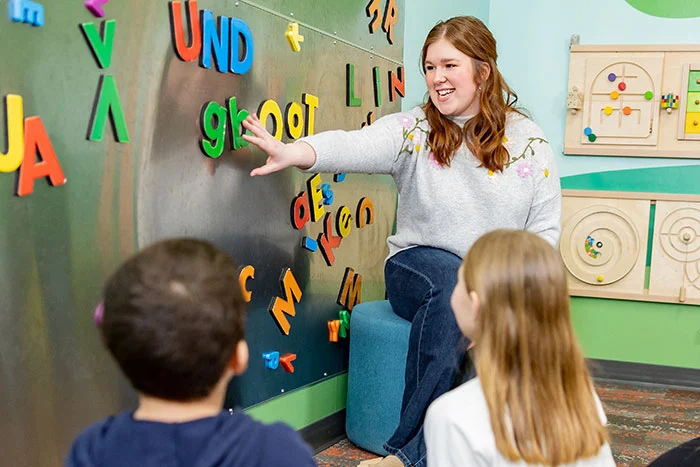 teacher arranging letters on magnetic board