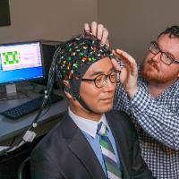 Headwear that analyzes brain functions is worn by man