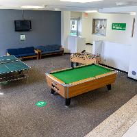 Common area with couches, pool table, ping pong table, and foosball
