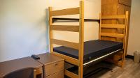 Noren Hall standard room bed, desk, and wardrobe.