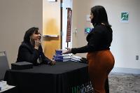 Dean Tomiko Brown-Nagin, 2024 keynote speaker talking with a student about her latest book.