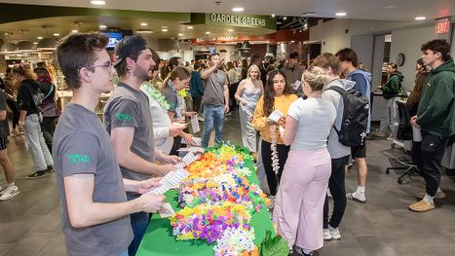 Housing staff members greet students who enter the Dining Center for Moonlight Luau