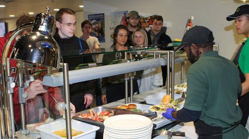 Students go through a service line for Alaskan crab legs
