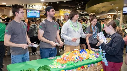 Housing staff members greet students who enter the Dining Center for Moonlight Luau