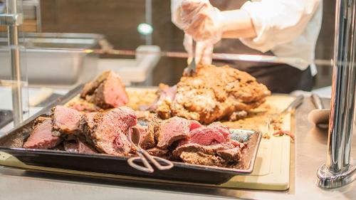 Chef carved roast beef ready to be self-served on a service line