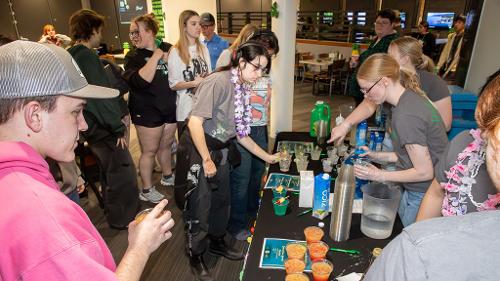 Housing student staff craft mocktail drinks for Moonlight Luau students
