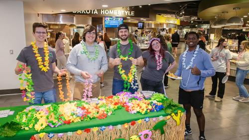 Housing staff members greet students who enter the Dining Center for Moonlight Luau