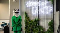 Large study room with a large greenery wall with the Fighting Hawk mascot next to a neon Home At UND sign