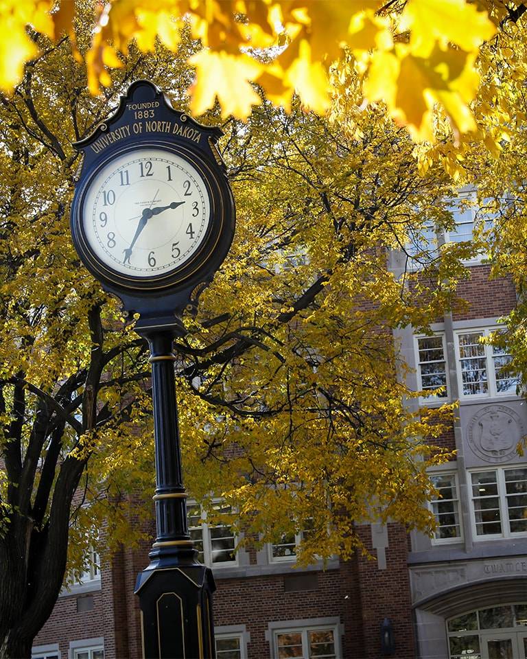 clock with text "Founded 1883 University of North Dakota" at top.