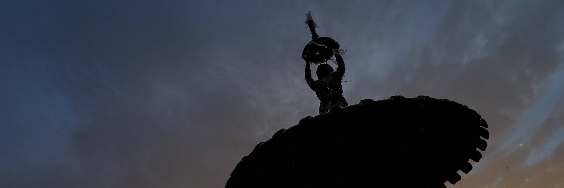 image of twilight sky and silhouette of Adelphi fountain on UND's campus.