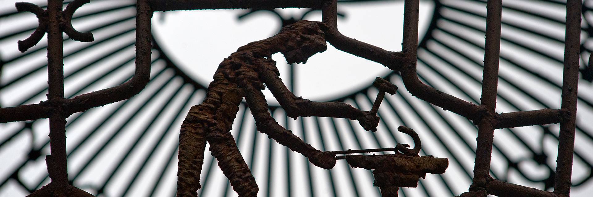 Closeup of Eternal Flame sphere/sculpture on UND campus. Figure shown is metal worker, hammering a piece of work.