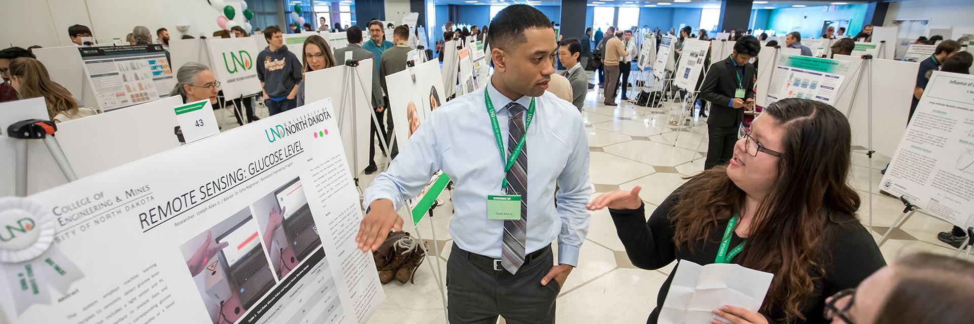 A student presents his research topic at a Graduate Expo