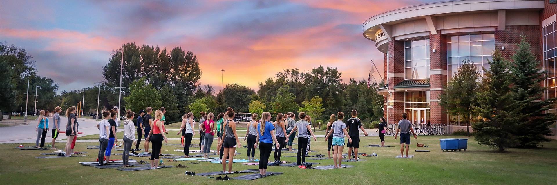 Group doing yoga in front of UND Wellness Center