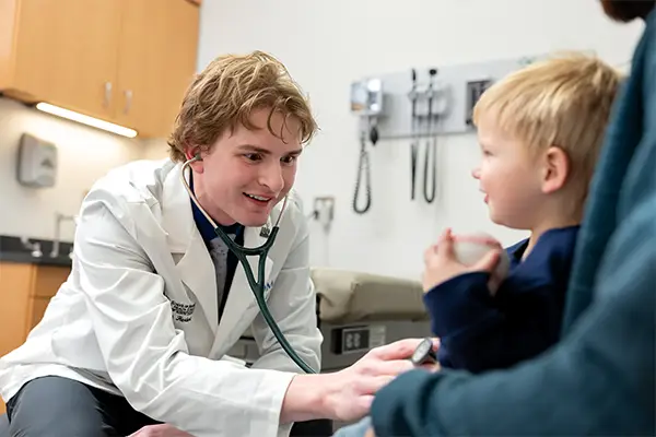student carson herbert performing medical exam on patient