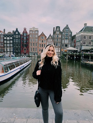 Student in front of canal in Amsterdam.