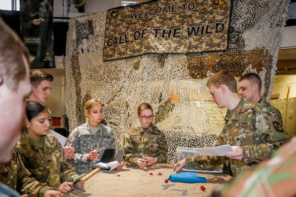 students working with military advisor