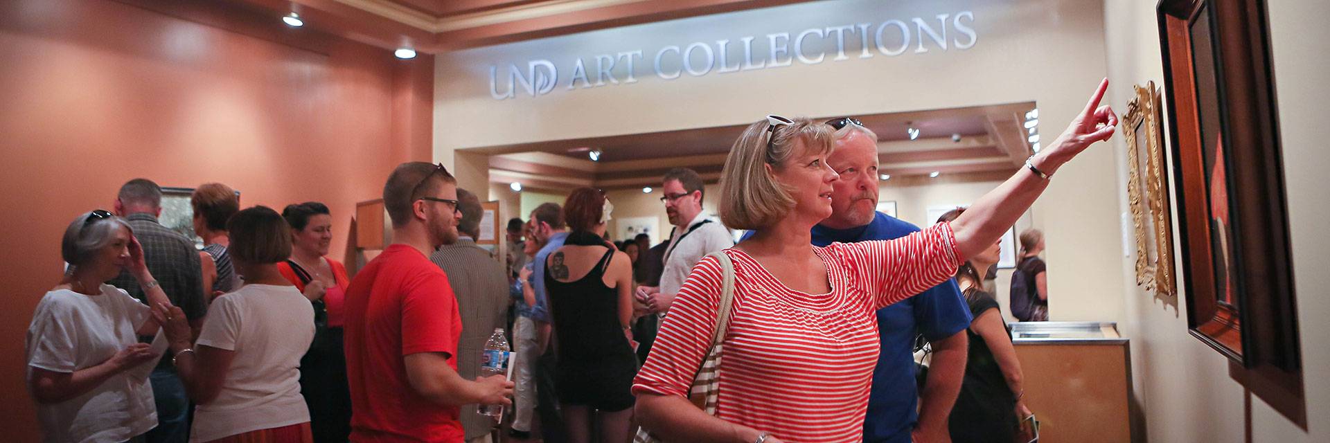 man and woman looking at painting in gallery