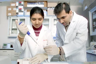 A biomedical student and professor collaborate in the lab