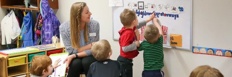 A special education teacher conducting interactive activities with her students in the classroom