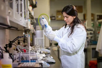 a female biomedical student conducts research in the laboratory, focusing intently on her work