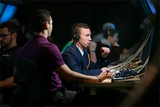 An air traffic control student in a headset works at a radar console in a darkened lab.