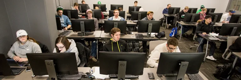 A classroom of computer science students focused on their computers.