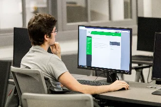 a cybersecurity student looking at his computer