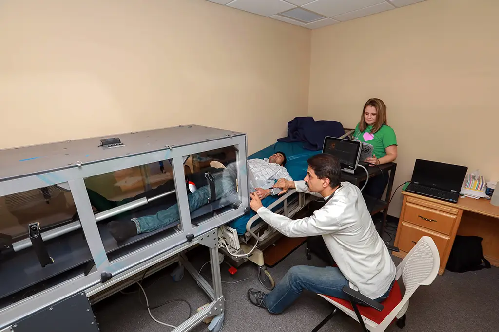 Hands on experience for biomedical engineering students collecting human data using specialized medical research equipment in a clinical lab.