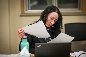 A psychology student is looking at her notes in the campus library, preparing for an upcoming exam