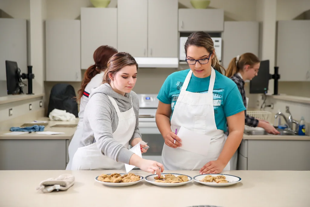 Nutrition students analyzing nutrition values in a classroom kitchen setting.