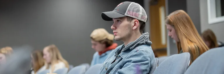 A forensic psychology student in class, attentively listening to the lecture
