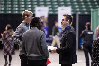 Communication students engaging with employers at a career fair.