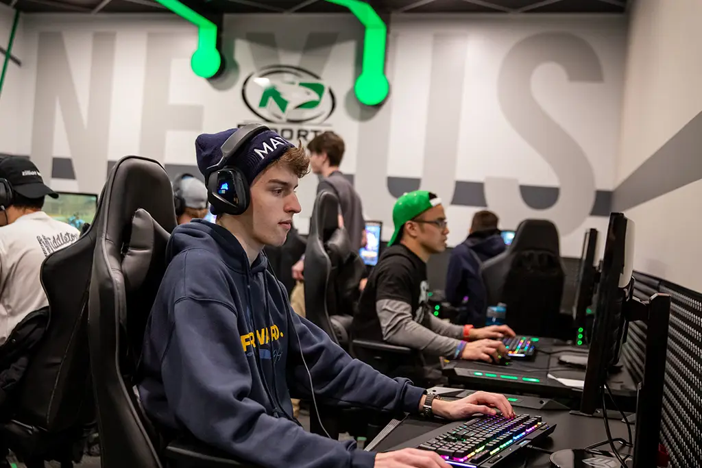 A young esports student wearing a headset, fully immersed in an exciting video game session.