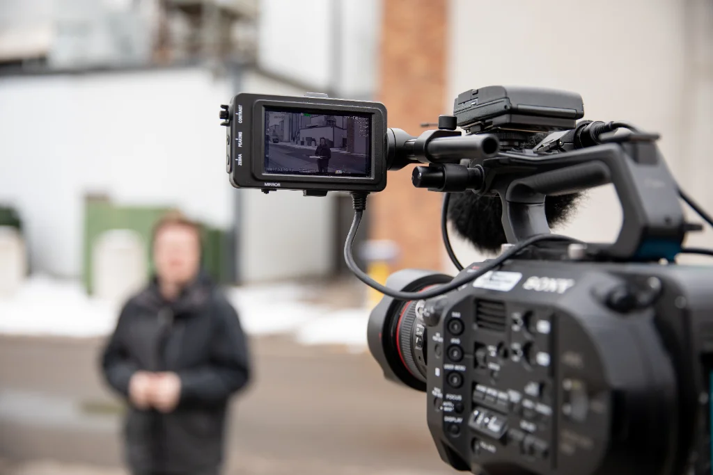 View through a professional camera recording a reporter in action