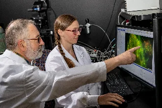 Two biomedical engineers focus on a computer screen, delving into innovative research