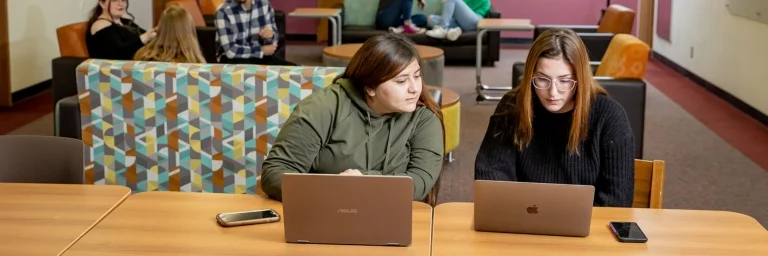 two female students with laptops