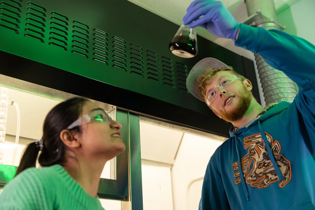 Two students examining lab results from a dinosaur fossil.