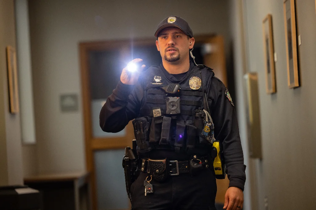 Police officer in uniform, engaged in a law enforcement activity.