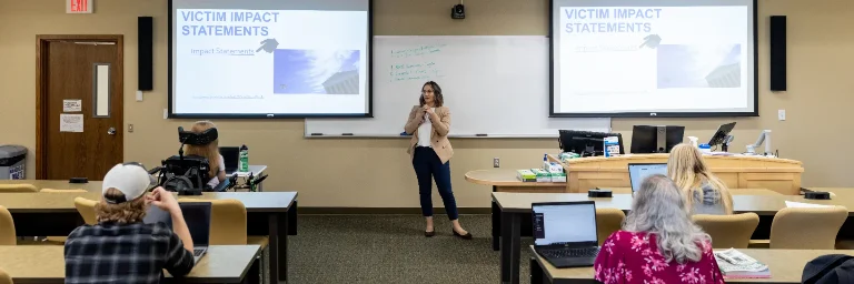 A group of criminal justice students attentively listens to their professor's lecture.