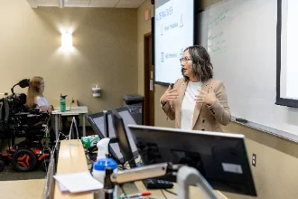 Female criminal justice professor lecturing in front of students.