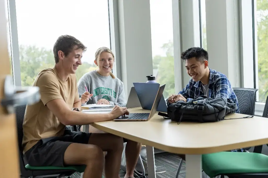Three cyber security students are engaged in a collaborative study session
