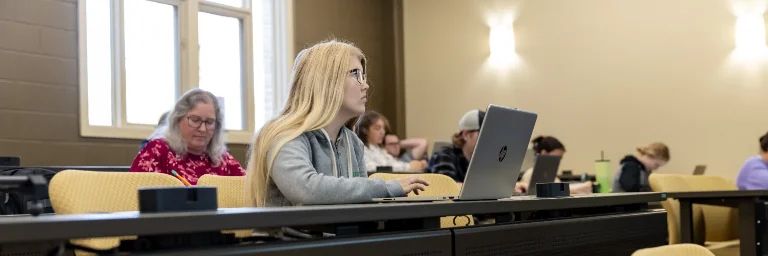 A group of criminal justice students attentively listens to their professor's lecture.