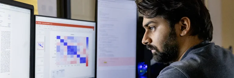 A male student deeply focused on solving cybersecurity challenges on his computer