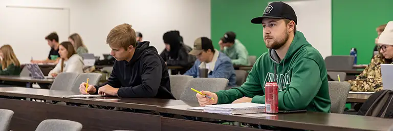 A group of students attentively listening to a lecture in an applied economics class.